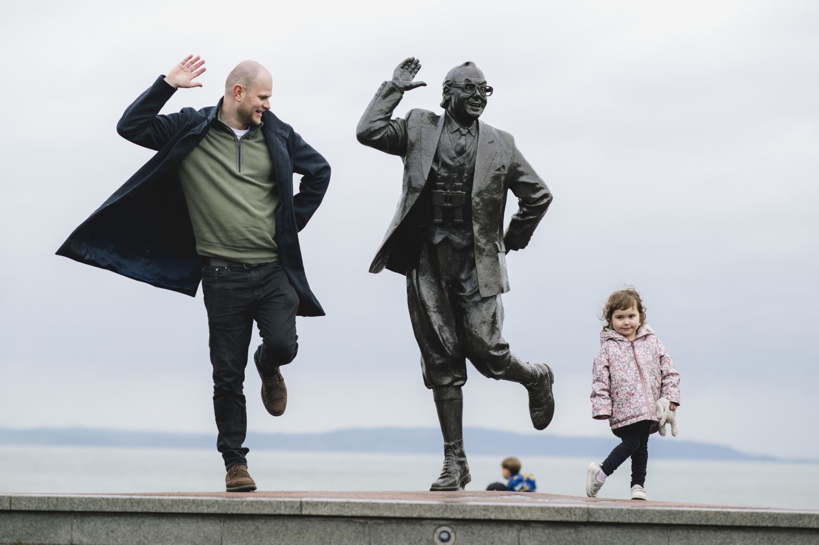 Family posing with Eric Morecambe Statue in Morecambe 